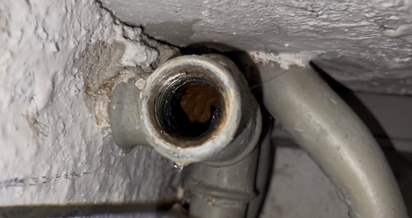 Undichte Rohrverschraubung in einer Wand, aus der kontinuierlich Wasser austritt – Beispiel für eine Feuchtigkeitsursache ohne Rohrbruch