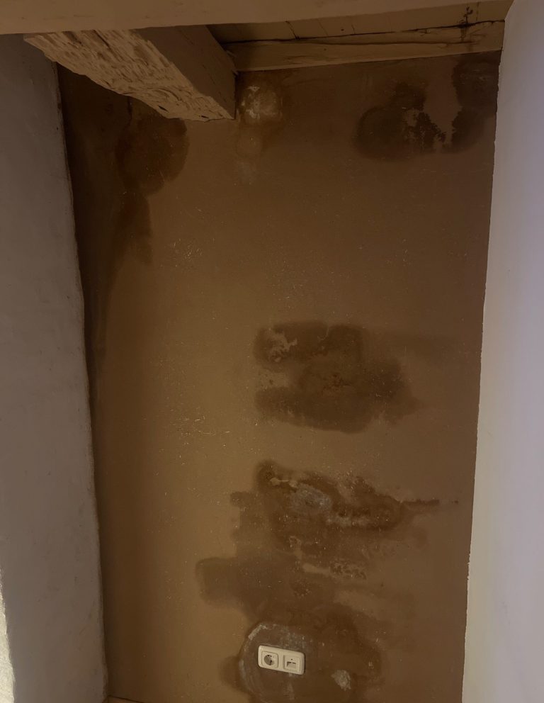 Wand mit sichtbaren Wasserflecken und Feuchtigkeitsschäden als typisches Anzeichen für einen Rohrbruch oder Wasseraustritt