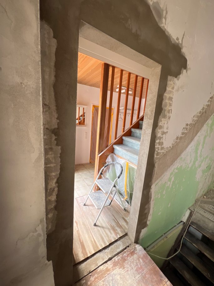 Geöffnete Innenwand nach einem Wanddurchbruch; neu geschaffener breiter Durchgang mit verputzten Laibungen und freiem Blick in den Flur